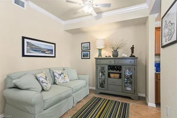 a living room with furniture and paintings on the wall