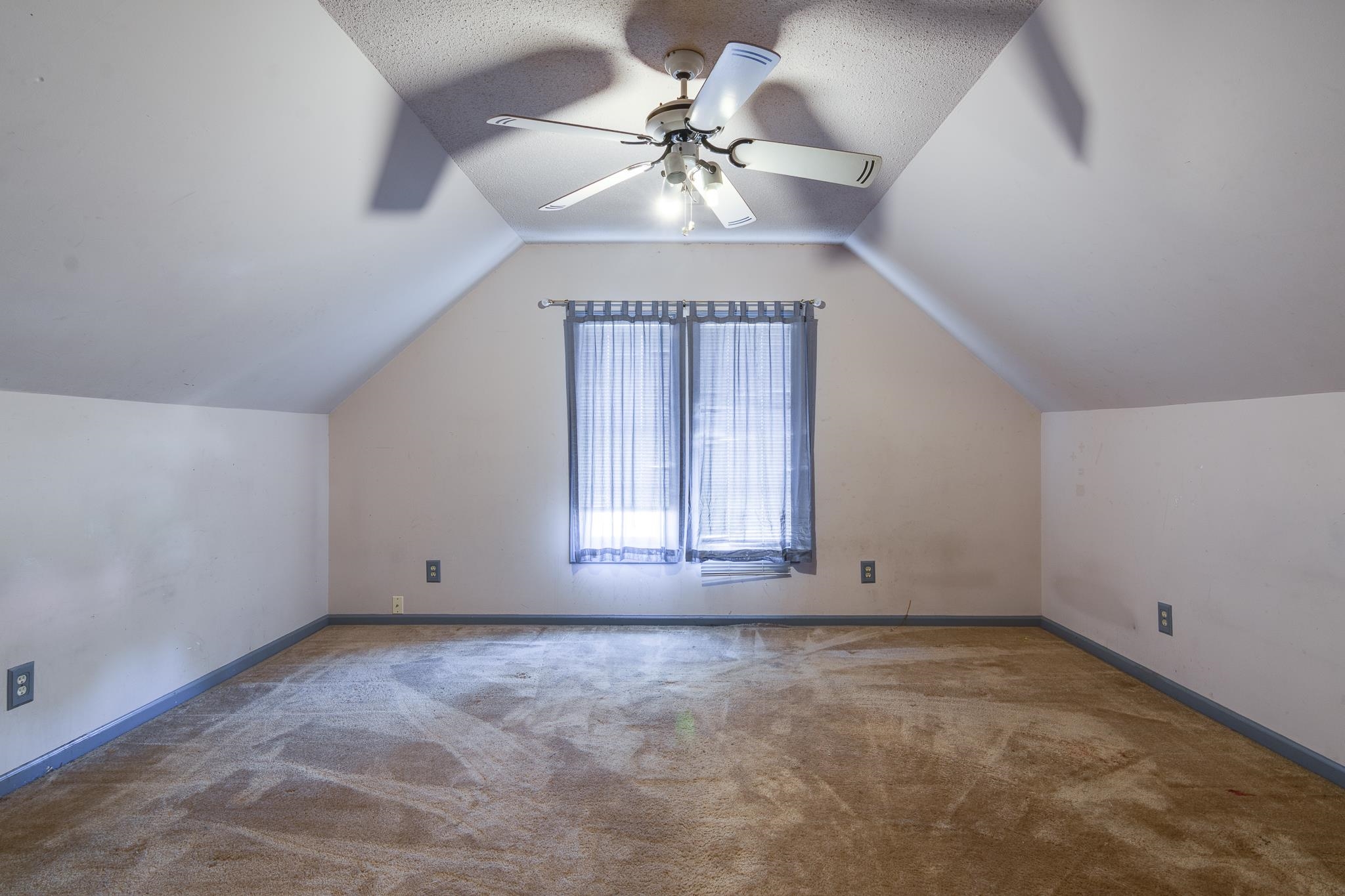 8083 Cinders Road Bartlett, TN 38133 - Photo 24 of 31 Room featuring sloped ceilings, a central ceiling fan with integrated lighting, and a single window with sheer coverings