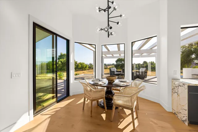 a view of a dining room with furniture large windows and wooden floor