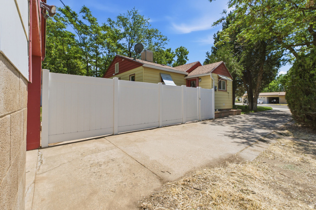 94 West 2000th Street North Clearfield, UT 84015 - Photo 19 of 26 Side driveway area with vinyl fencing, gated access, and view of the home’s exterior.