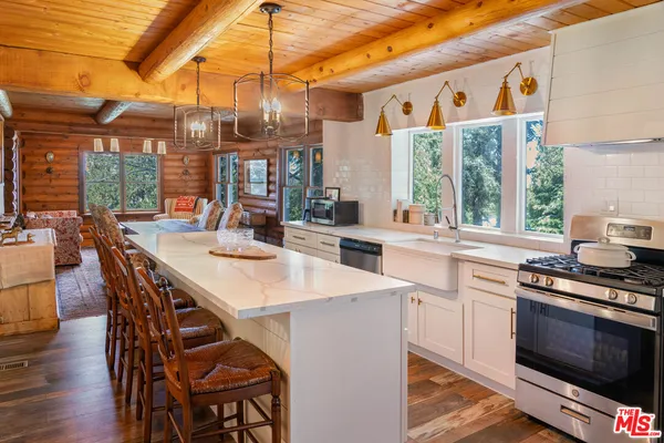 a open kitchen with stainless steel appliances a stove a table and chairs