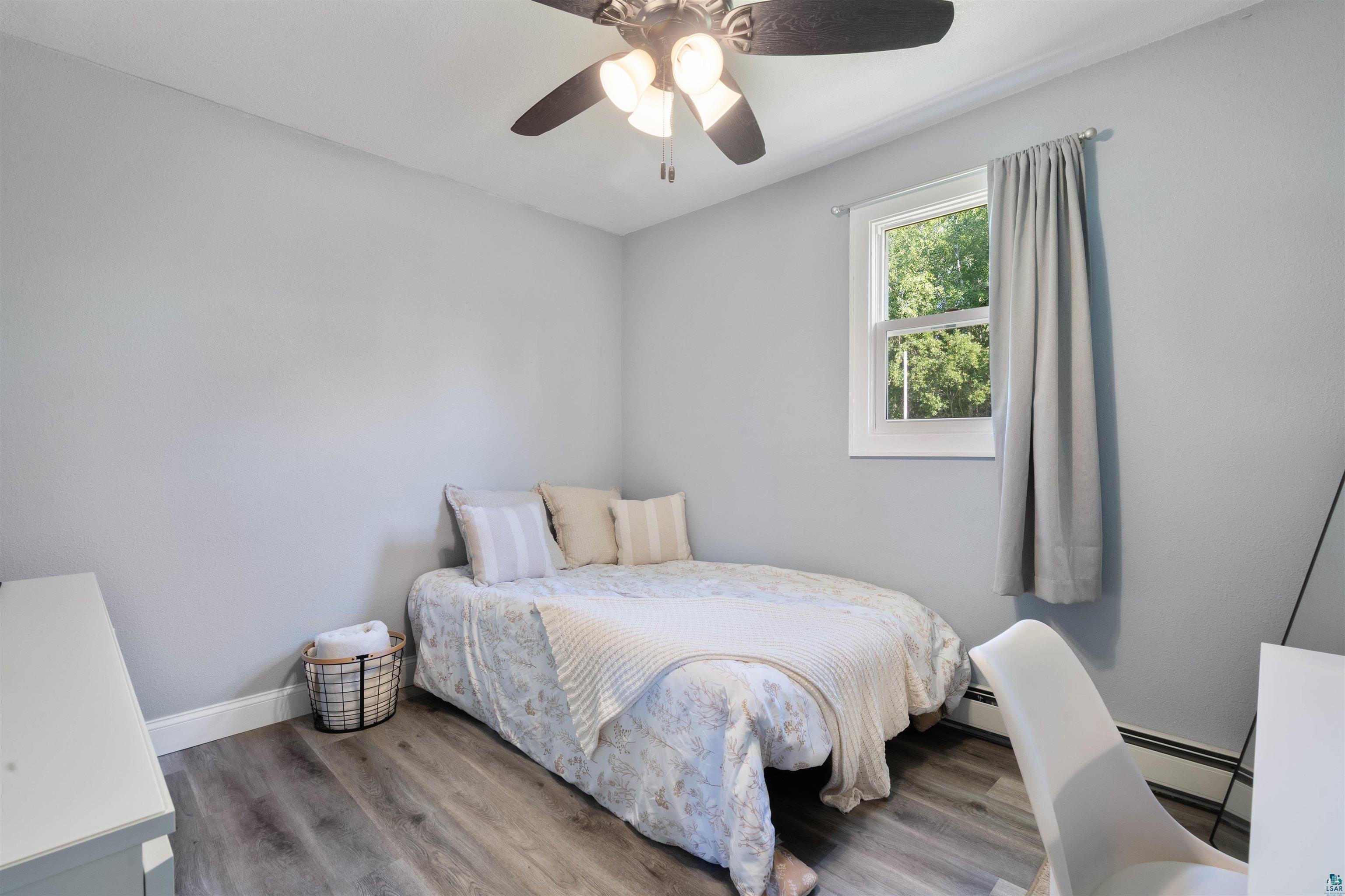 3835 South County Rd K South Range, WI 54874 - Photo 13 of 29 Bedroom featuring wood-finish flooring, a white-framed window, and a ceiling fan with integrated lighting