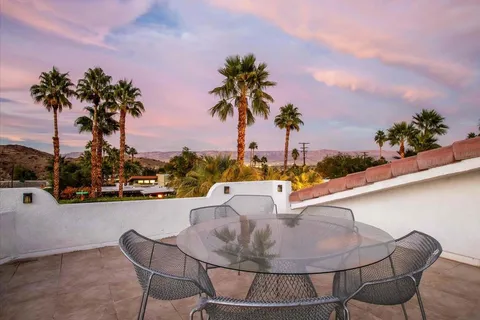 a dining room with furniture and large windows