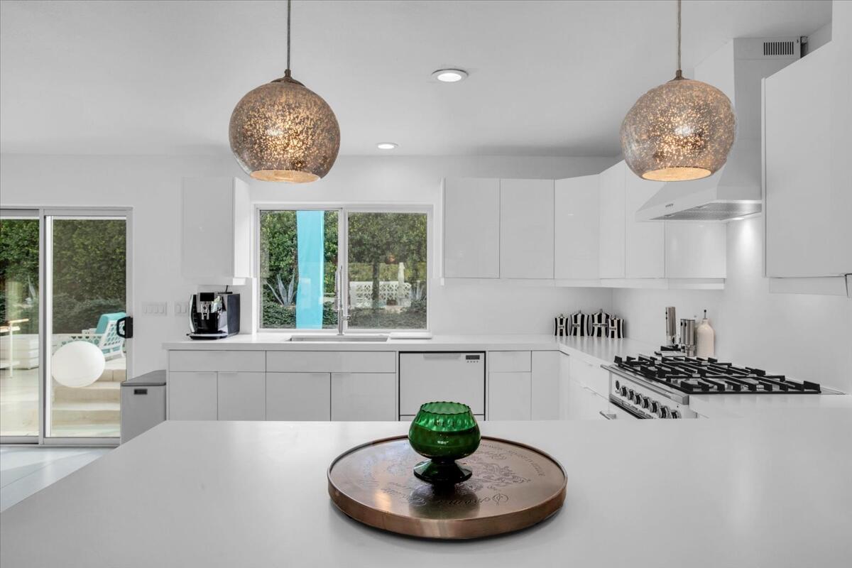 68159 Mountain View Road Cathedral City, CA 92234 - Photo 30 of 77 a dining room with wooden floor a chandelier a wooden table and chairs
