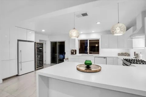 a living room with stainless steel appliances kitchen island granite countertop furniture and a large window
