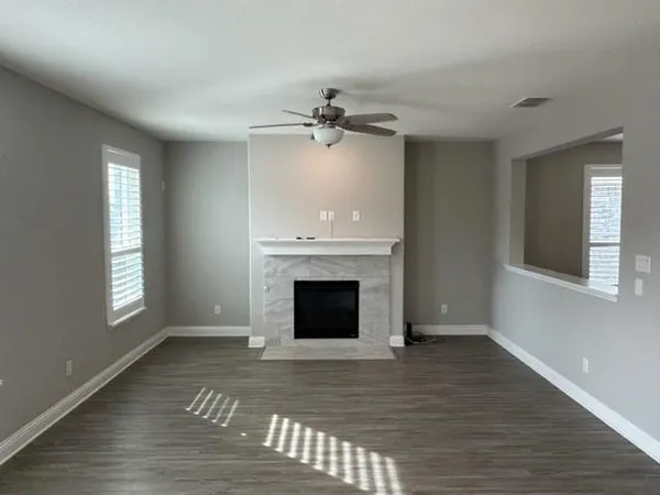wooden floor fireplace and windows in an empty room