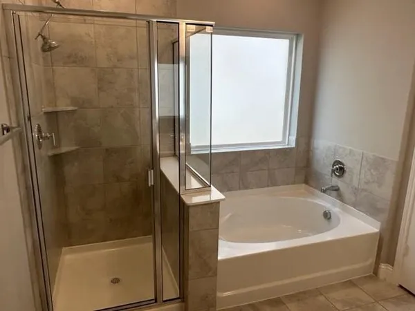 a white bath tub sitting next to a shower