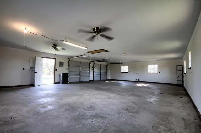 an empty room with a ceiling fan and windows