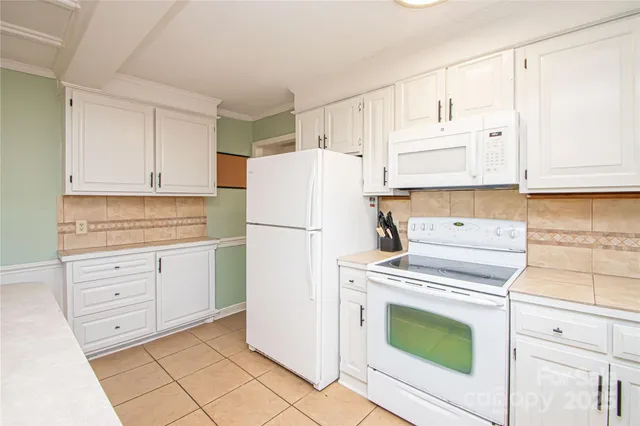 a kitchen with cabinets a refrigerator and a stove top oven