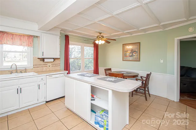 a kitchen with a stove a sink a dining table and chairs