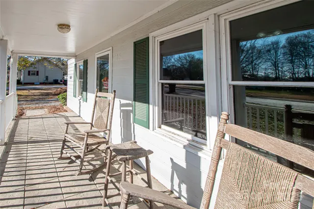 a view of a patio with table and chairs with wooden floor and fence