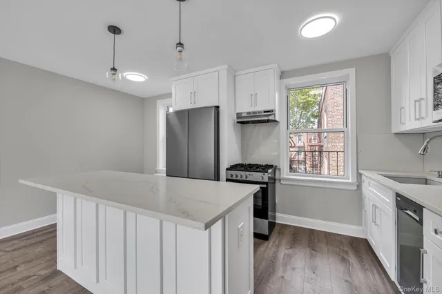 a kitchen that has a cabinets a sink a window and appliances