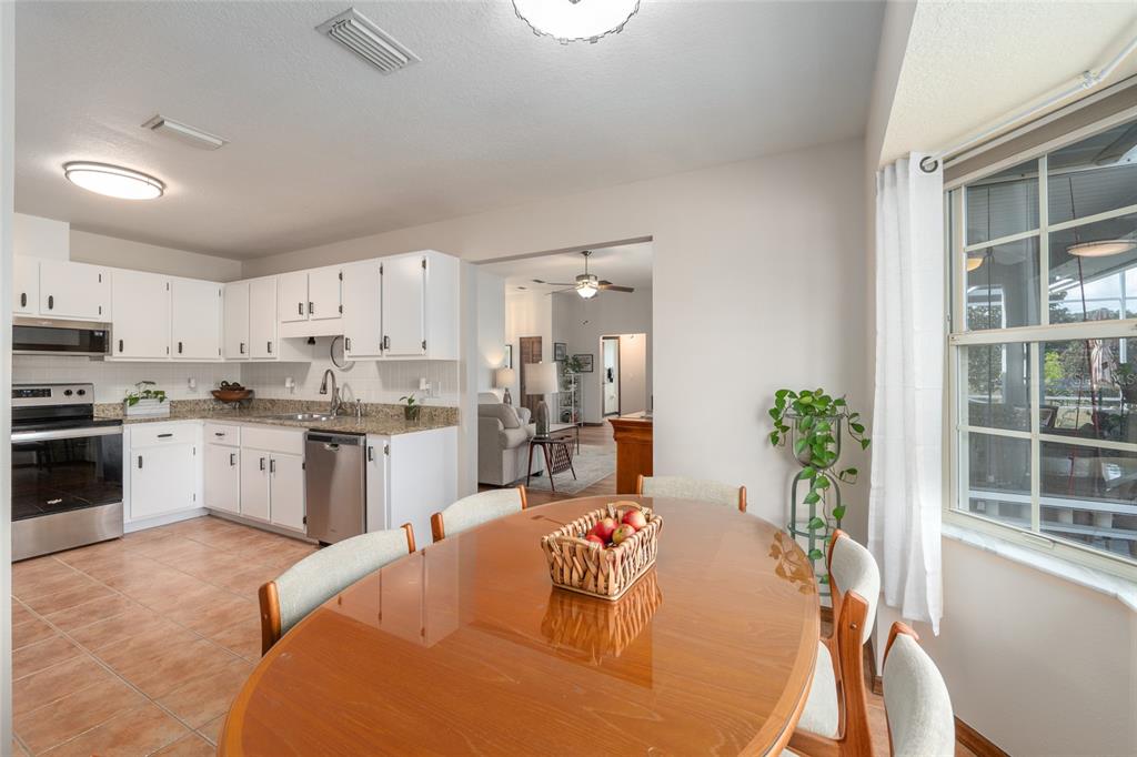 12094 Southeast 60th Avenue Road Belleview, FL 34420 - Photo 21 of 74 a large white kitchen with cabinets a counter top space a sink stainless steel appliances and cabinets
