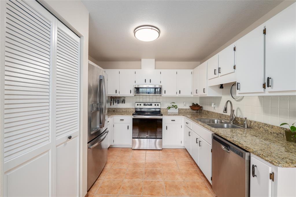 12094 Southeast 60th Avenue Road Belleview, FL 34420 - Photo 22 of 74 a kitchen with stainless steel appliances granite countertop a stove sink and cabinets
