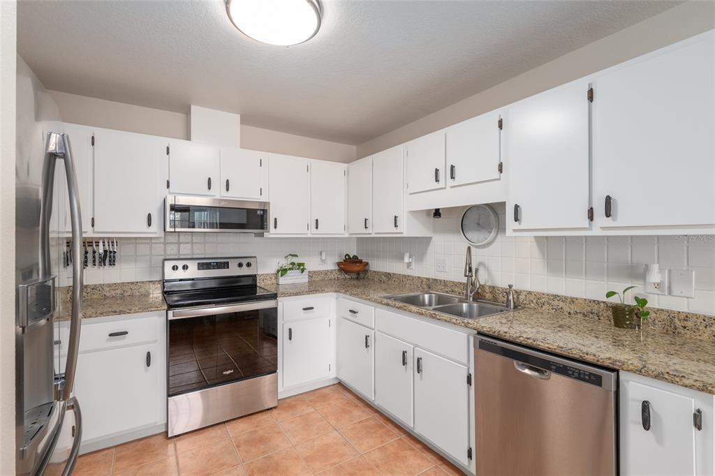 12094 Southeast 60th Avenue Road Belleview, FL 34420 - Photo 23 of 74 a kitchen with stainless steel appliances granite countertop a sink stove refrigerator and cabinets
