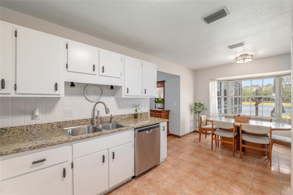 12094 Southeast 60th Avenue Road Belleview, FL 34420 - Photo 25 of 74 a kitchen with granite countertop white cabinets sink and stainless steel appliances