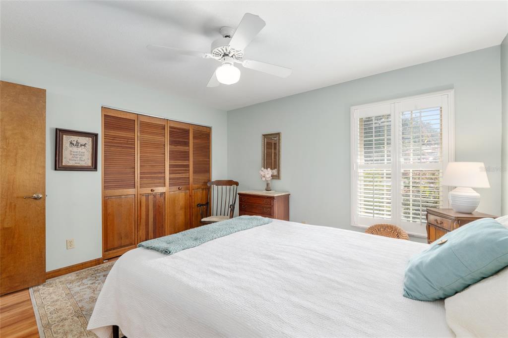 12094 Southeast 60th Avenue Road Belleview, FL 34420 - Photo 37 of 74 a bedroom with a large bed and wooden floor