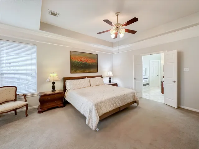 a spacious bedroom with a bed and ceiling fan