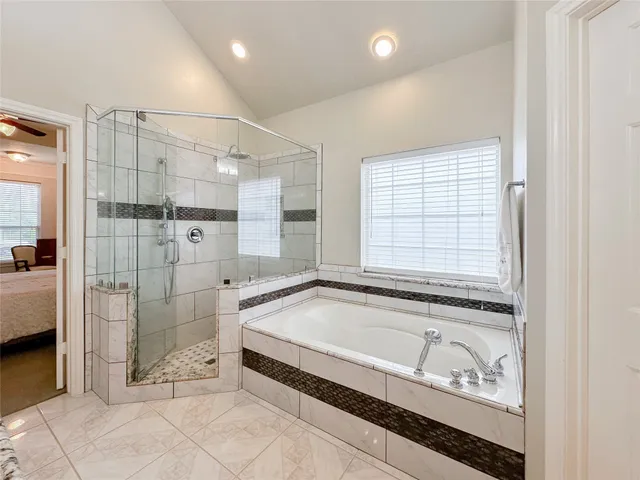 a spacious bathroom with a granite countertop tub shower and sink