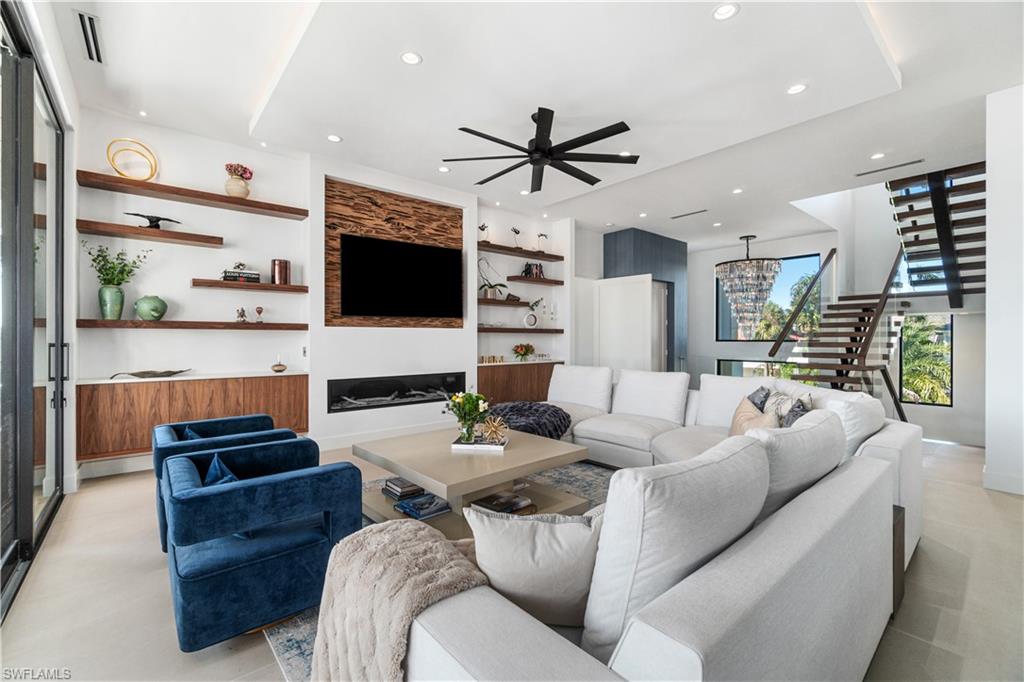 448 Oak Avenue Naples, FL 34108 - Photo 17 of 49 Tiled living room featuring ceiling fan with notable chandelier