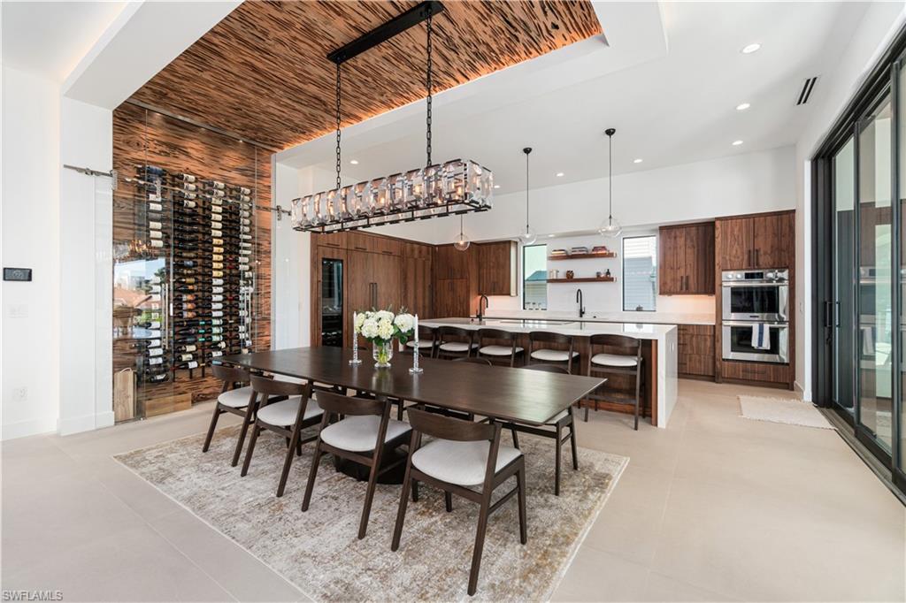 448 Oak Avenue Naples, FL 34108 - Photo 18 of 49 Tiled living room featuring built in shelves, a baseboard heating unit, and ceiling fan
