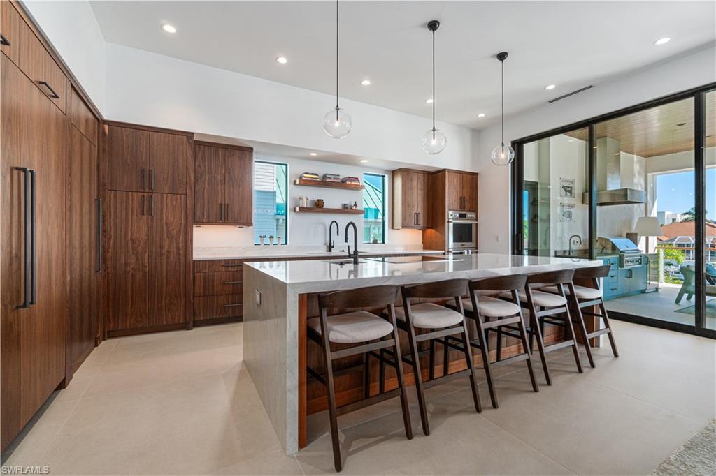 448 Oak Avenue Naples, FL 34108 - Photo 20 of 49 Dining room with light tile patterned floors, a chandelier, and a tray ceiling