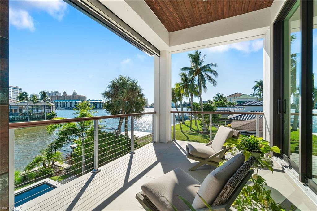 448 Oak Avenue Naples, FL 34108 - Photo 28 of 49 Bedroom featuring access to exterior, wood-type flooring, a tray ceiling, and ceiling fan