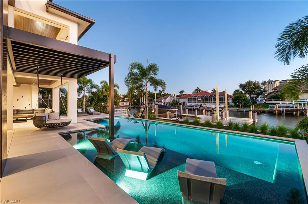 448 Oak Avenue Naples, FL 34108 - Photo 5 of 49 Pool at dusk with a water view and a boat dock