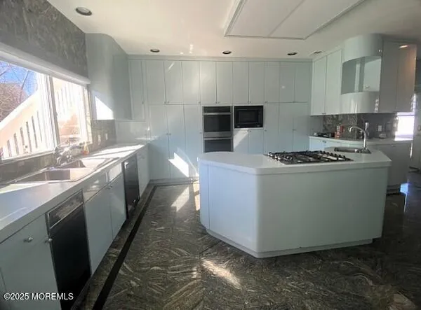 a kitchen with stainless steel appliances granite countertop a sink a stove and a refrigerator