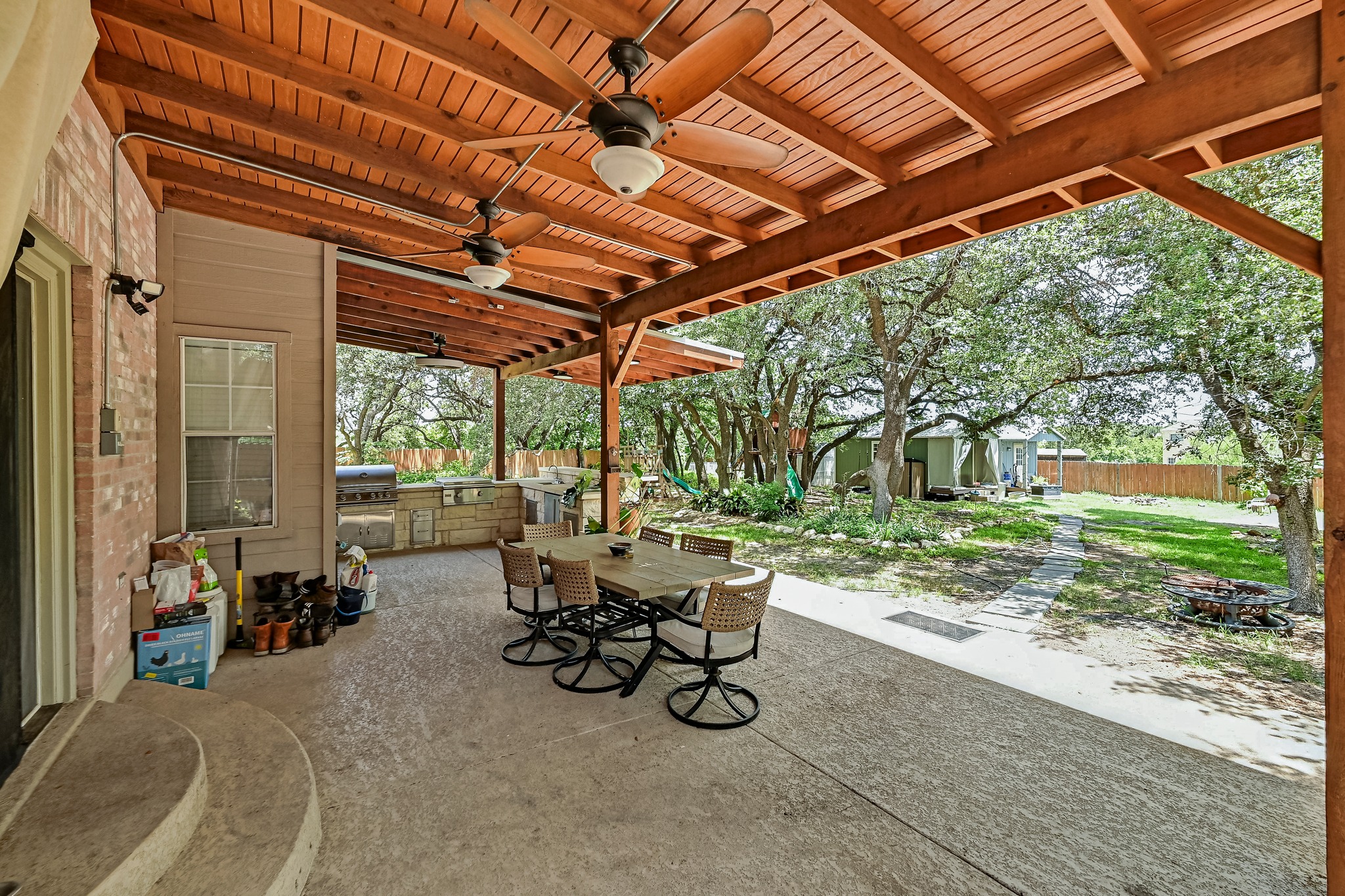 104 North Sumac Lane Georgetown, TX 78633 - Photo 38 of 40 A spacious covered patio provides a delightful outdoor living space with an integrated kitchen and serene yard views.