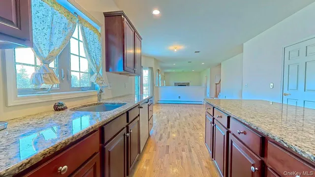 a kitchen with stainless steel appliances granite countertop a stove a refrigerator a kitchen island a dining table and chairs