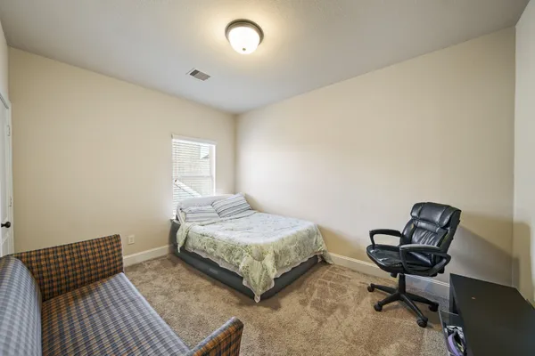 a bedroom with a bed window and chair