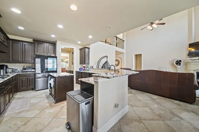 a large kitchen with kitchen island a sink a counter top stainless steel appliances and cabinets