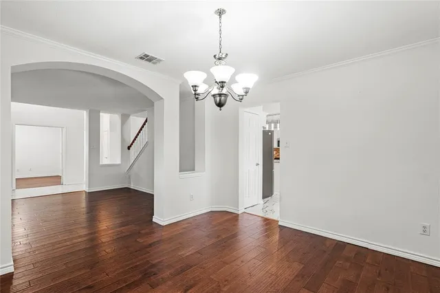 a view of a room with wooden floor and chandelier