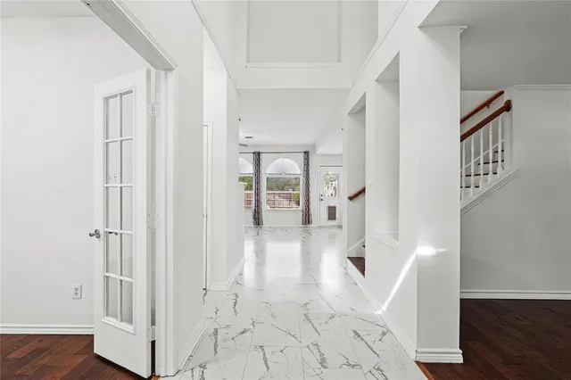 wooden floor with white walls and stairs