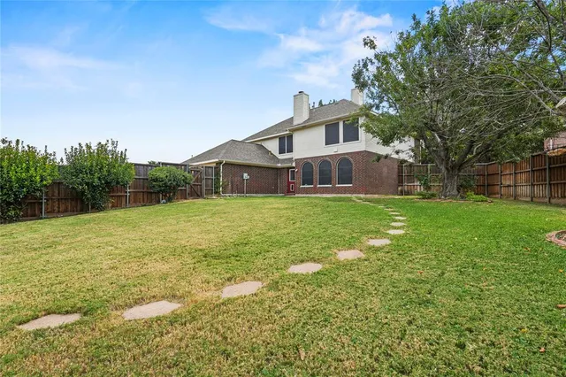 a view of a house with a yard and sitting area