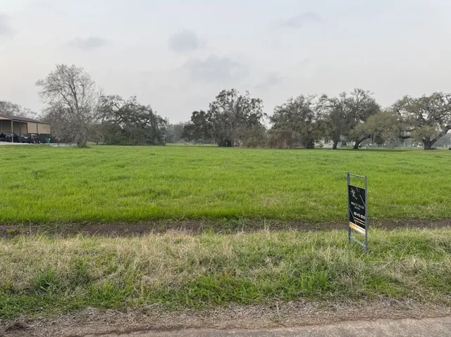 a view of a green field with wooden fence