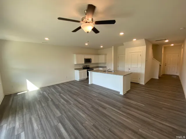 a view of kitchen with sink and refrigerator