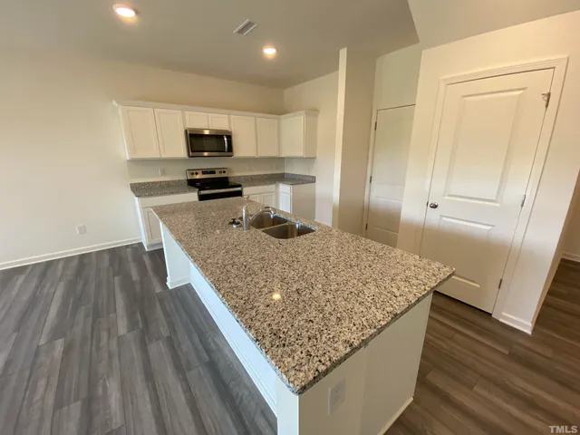 a kitchen with granite countertop wooden cabinets and stainless steel appliances