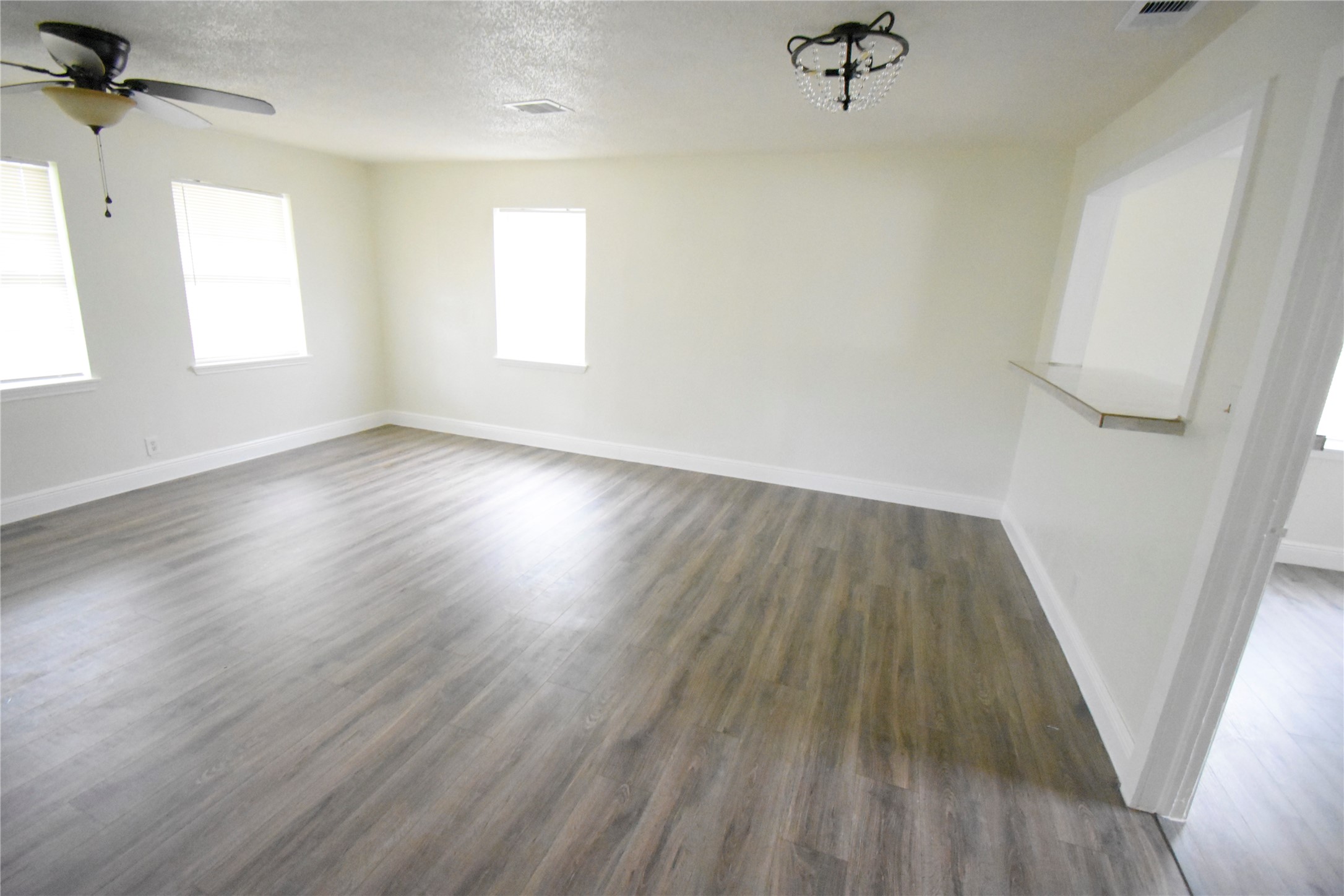 6229 Clover Ridge Street Houston, TX 77087 - Photo 13 of 25 an empty room with wooden floor and windows