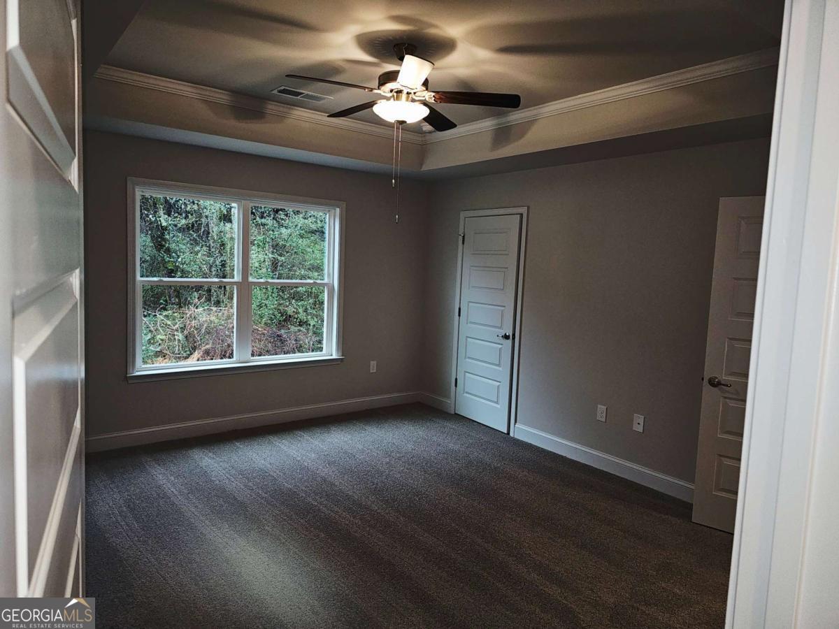 216 Rhett Drive, Unit 12 Bowdon, GA 30108 - Photo 7 of 10 a view of wooden floor and a chandelier fan in a room