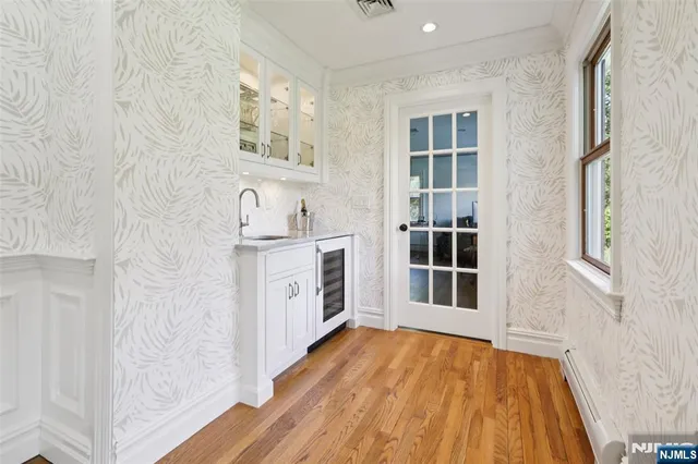 a view of a hallway with wooden floor and electronic appliances