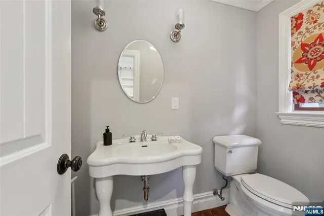 a bathroom with a toilet sink and mirror