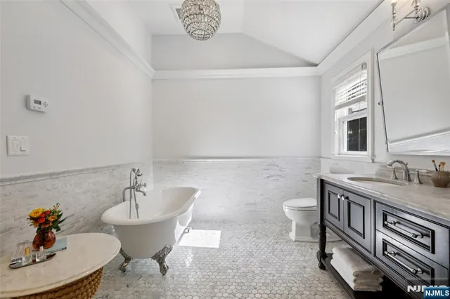 a spacious bathroom with a granite countertop sink a toilet and a mirror