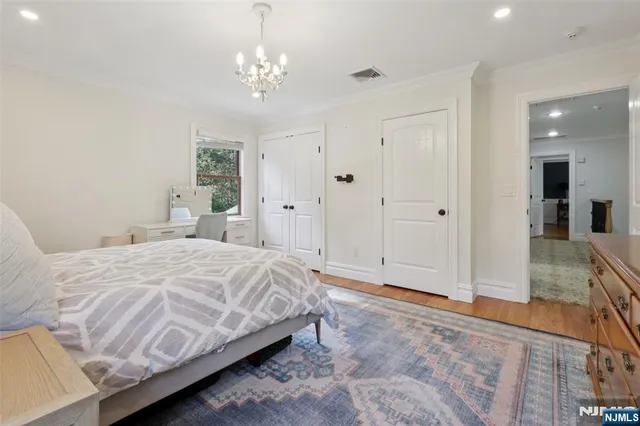 a spacious bedroom with a bed and a chandelier