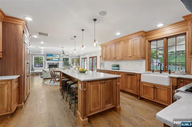 a kitchen with stainless steel appliances granite countertop a sink a stove and a wooden floors