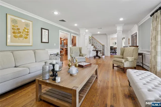a living room with furniture a large window and wooden floor