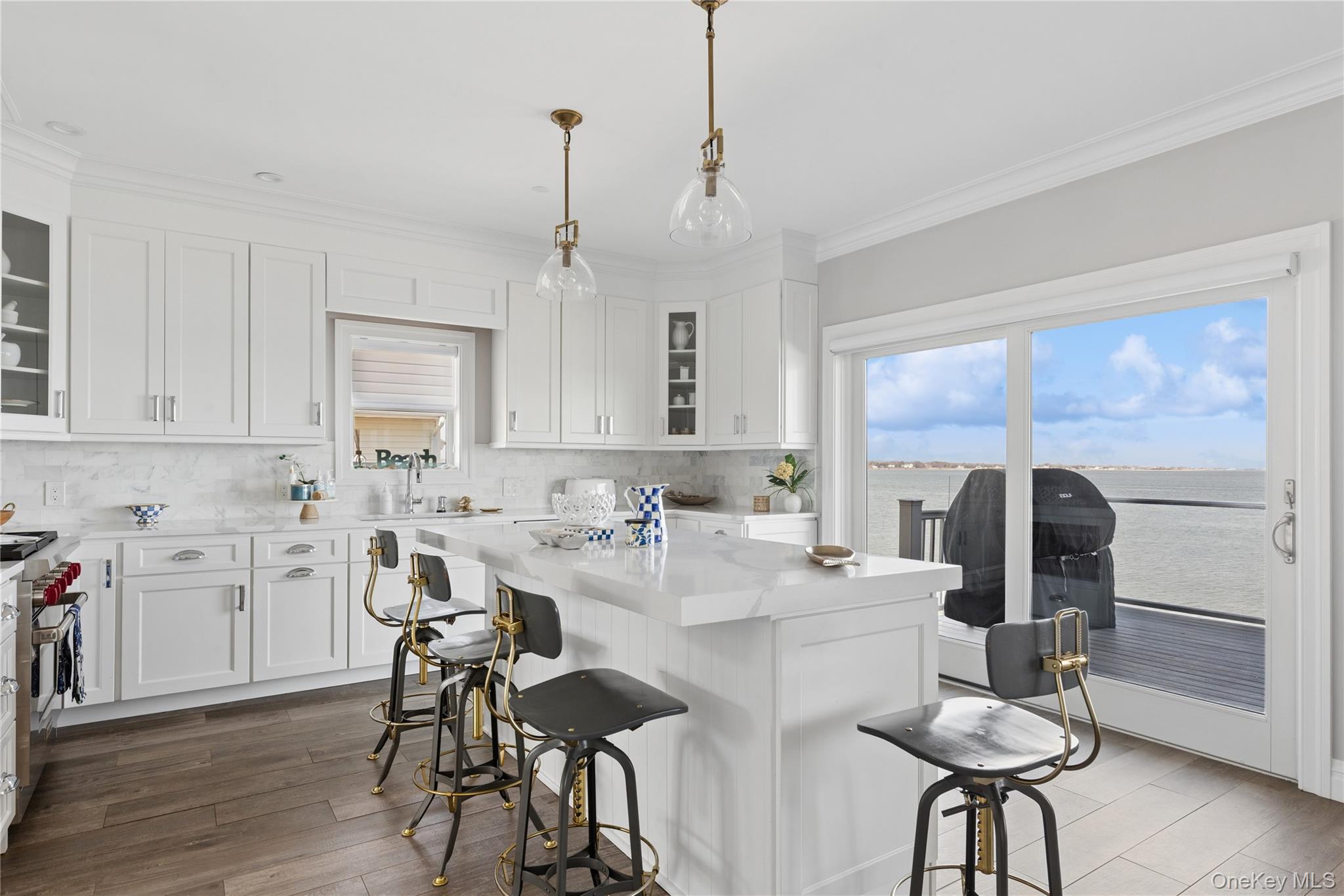 39 Shinnecock Road East Quogue, NY 11942 - Photo 14 of 35 a kitchen with stainless steel appliances kitchen island granite countertop a dining table chairs and granite counter tops