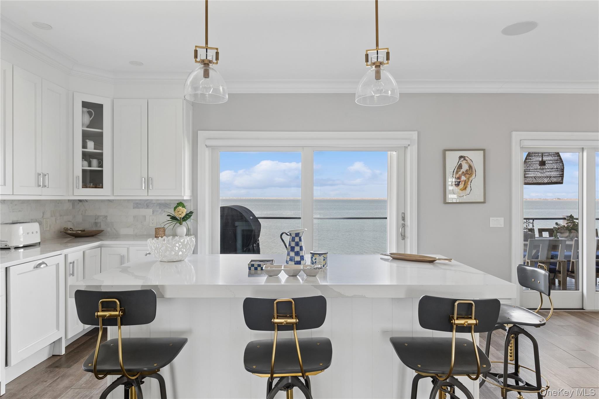 39 Shinnecock Road East Quogue, NY 11942 - Photo 15 of 35 a kitchen with a dining table chairs wooden floor and appliances