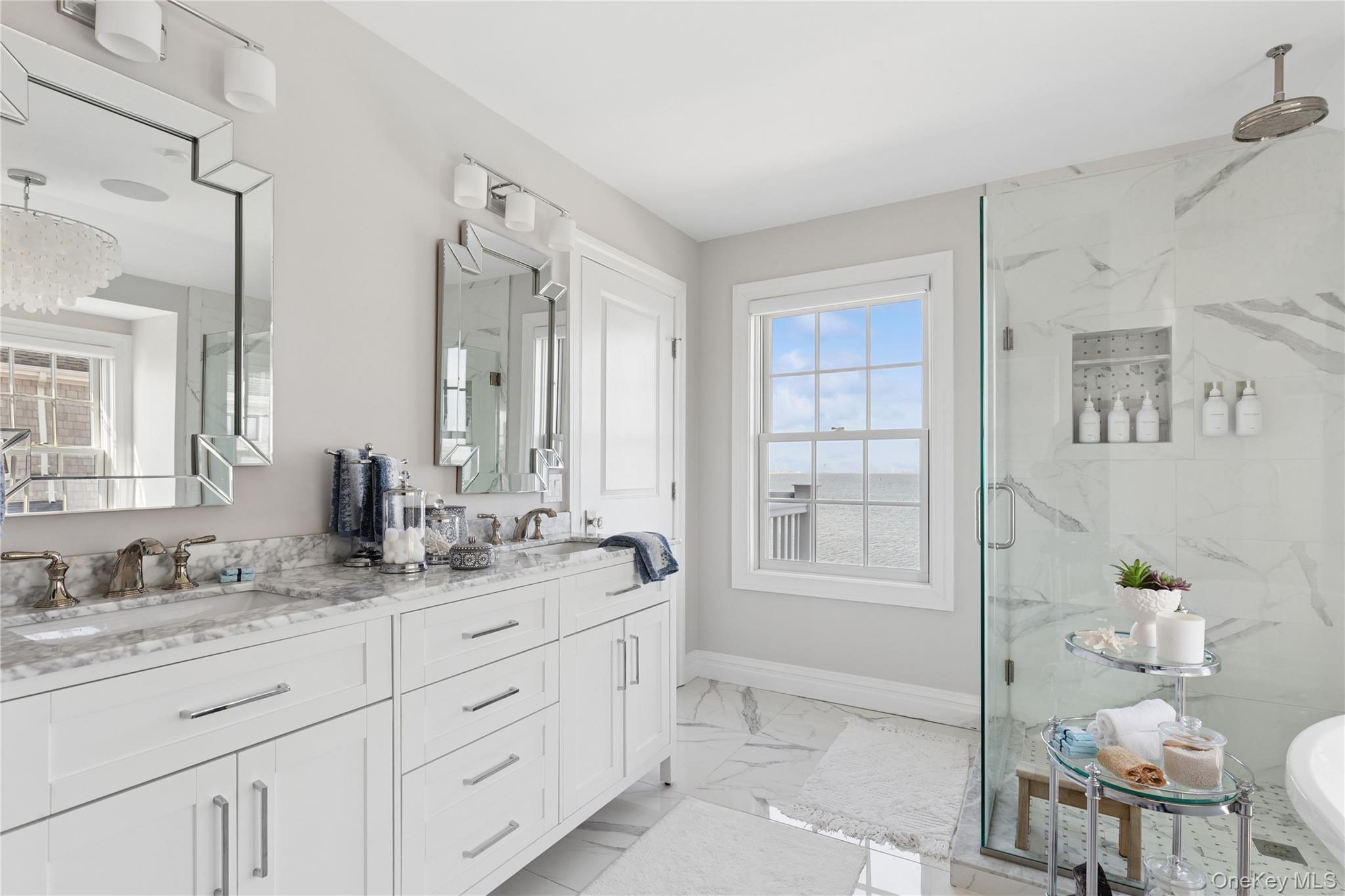 39 Shinnecock Road East Quogue, NY 11942 - Photo 26 of 35 a bathroom with double vanity sink a two mirror a window and a bathtub